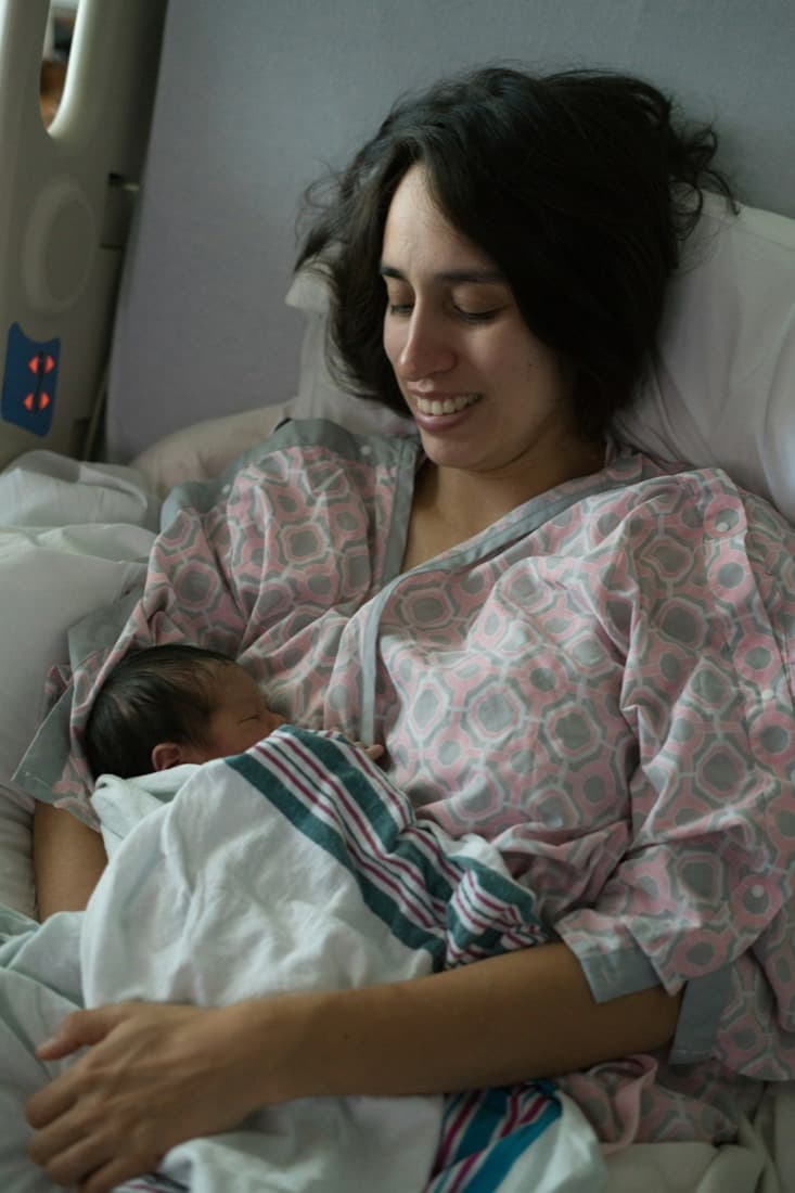 Mother holding her newborn baby in a hospital bed