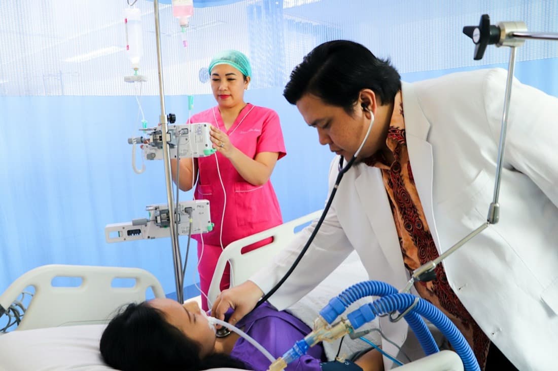 Doctor and nurse attending a patient in a hospital ward