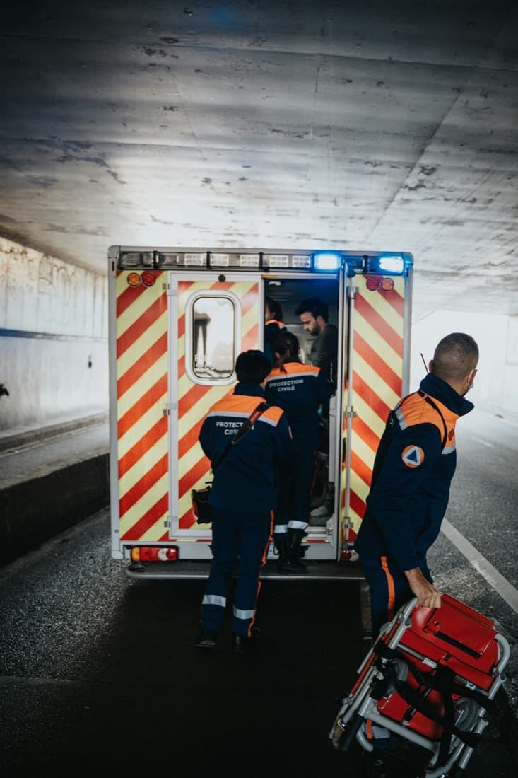 Paramedics loading a stretcher into an ambulance